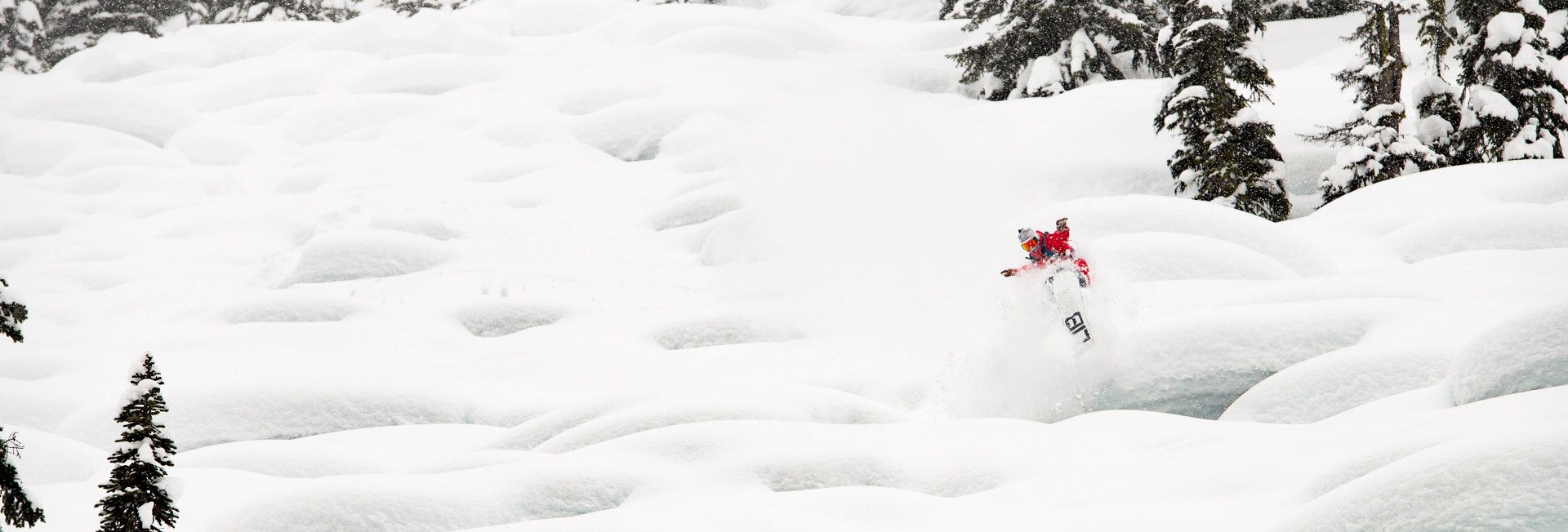 Austin Sweeting heli snowboarding pillow line at Stellar Heliskiing.